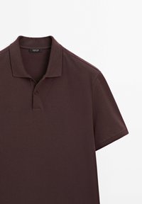 Burgundowa koszulka polo z krótkimi rękawami, prążkowanym kołnierzykiem i zapięciem na dwa guziki. Gładka tkanina o subtelnym tkanego wzorze.