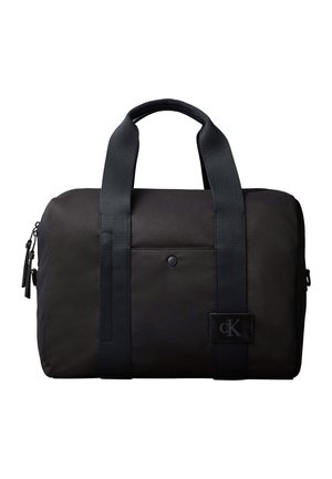 Sac de sport rectangulaire noir avec deux poignées, poche avant à pression, côtés zippés, et petit écusson logo Calvin Klein.