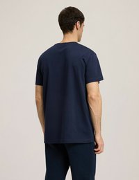 Granatowa bawełniana koszulka z krótkimi rękawami, okrągłym dekoltem i prostym krojem. Gładka tekstura z prostym, nieskomplikowanym wzornictwem.