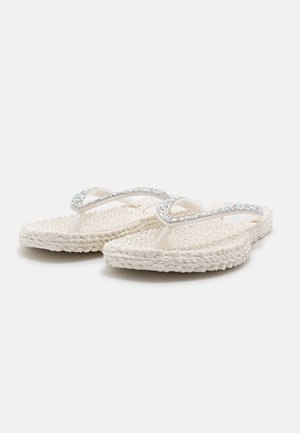 White woven-texture flip-flops with sparkly rhinestone-encrusted straps on a plain white background.