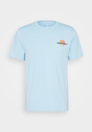 T-shirt en coton bleu clair à manches courtes, col rond, avec un logo "Converse" multicolore et un motif graphique sur la poitrine.