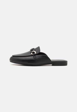 Chaussures en cuir noir à enfiler avec un bout arrondi, comportant un accent tissé et une semelle plate. Texture lisse et design minimaliste.