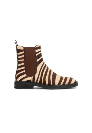 Botte Chelsea montant à la cheville avec rayures zèbre marron et crème, semelle noire et panneaux latéraux élastiques marron.