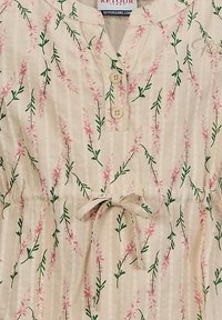 Bluse mit Blumenmuster und pinken sowie grünen Pflanzenmotiven auf einem beige gestreiften Hintergrund, ausgestattet mit einer Knopfleiste und einem Kordelzug in der Taille.