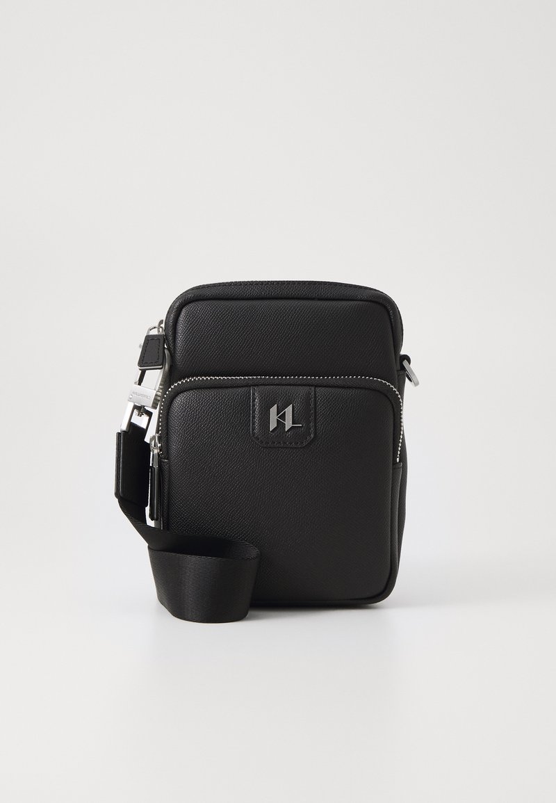 Borsa a tracolla nera in sintetico con finitura texturizzata, cerniere argentate, tracolla regolabile e logo impresso sul davanti.