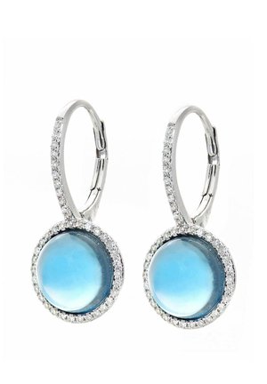 Orecchini a cerchio in argento con centri di pietre preziose tonde blu circondate da un alone di piccole pietre trasparenti per un dettaglio aggiuntivo.