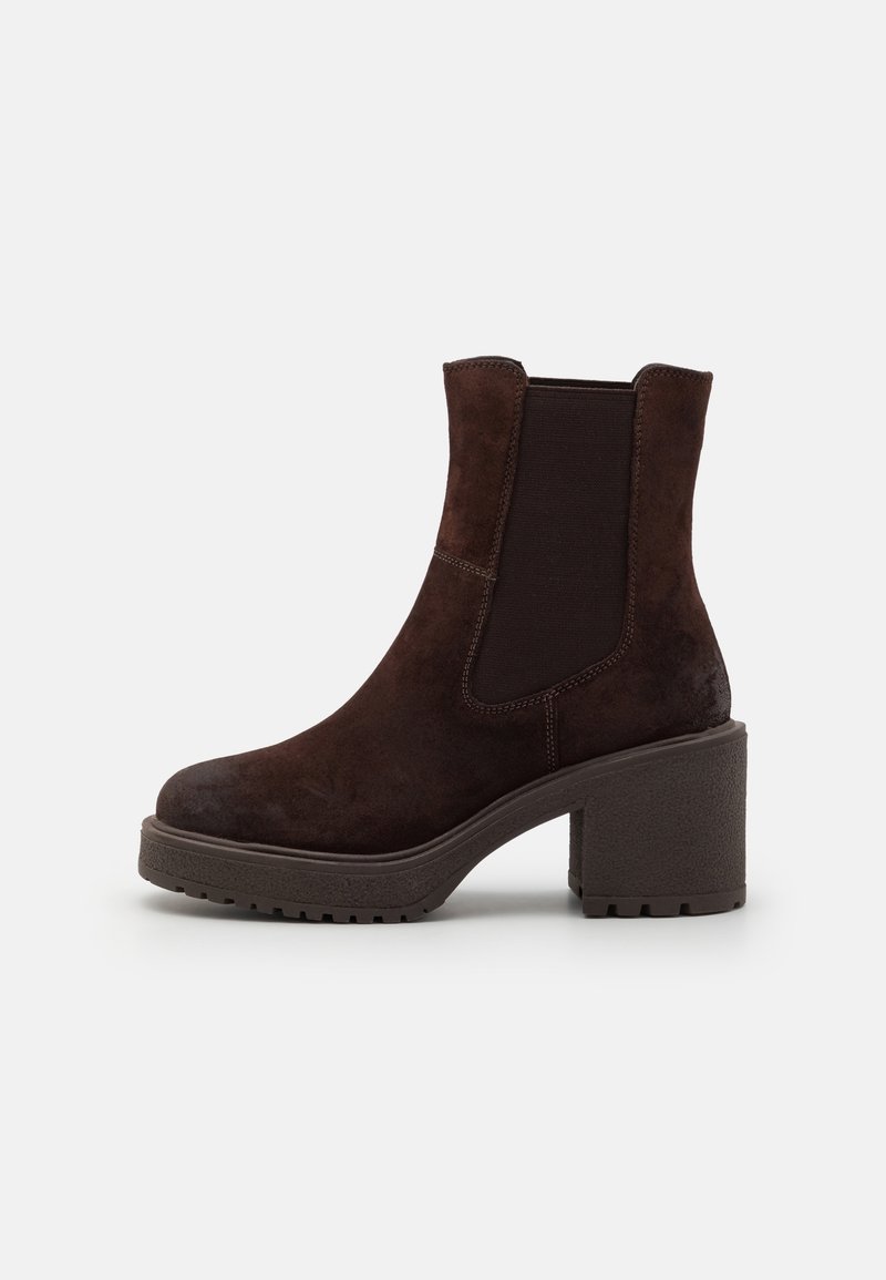 Bottines en daim marron à talon bloc épais, avec panneaux latéraux élastiques et semelle en caoutchouc texturée, ornées de surpiqûres le long des coutures.
