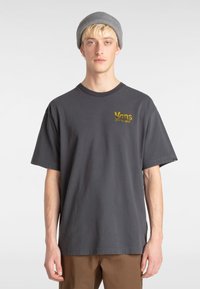 Dark gray short-sleeve t-shirt made of cotton. Features yellow embroidered "Vans" logo on the left chest. Relaxed fit with a classic crew neck.
