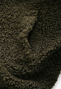 Dunkelgrüner, strukturierter Stoff mit einer flauschigen, geschlungenen Oberflächenmusterung. Weiches Material mit einem dicken, plüschigen Gefühl, geeignet für kuschelige Anwendungen.