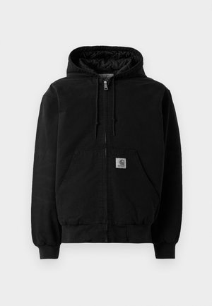 Crna zip-jakna s kapuljačom, prednjim džepovima, školjkom s uzicom, rebrastim manžetama i malim Carhartt logom na džepu.