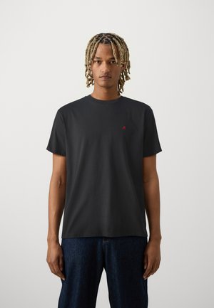T-shirt nera a maniche corte, realizzata in cotone liscio, con un piccolo logo rosso sul lato sinistro del petto, colletto tondo e vestibilità rilassata.