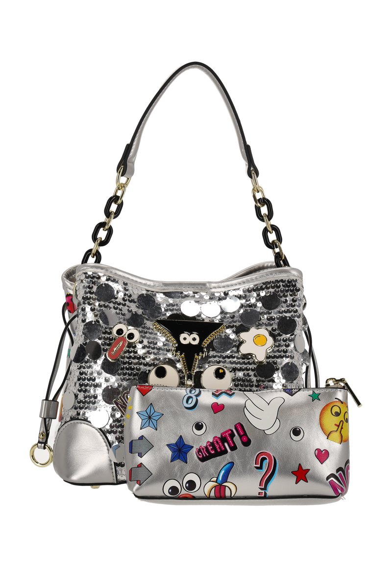 Ezüst flitteres kézitáska lekerekített formával, rajzfilmszerű foltokkal és egy levehető ezüst neszesszerrel, amelyet színes matricák díszítenek.