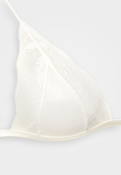 Bralette bianco in pizzo con coppe triangolari, caratterizzato da un design in mesh testurizzato e bordi delicati. Sottile spalline si collegano alle coppe.
