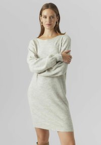 Abito maglione grigio chiaro a maglia con scollatura ampia, maniche lunghe e polsini a coste, caratterizzato da una texture morbida e una vestibilità rilassata.