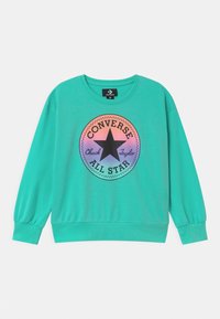 Sudadera turquesa con mangas largas, puños acanalados y cuello redondo. Presenta un gráfico circular multicolor con una estrella y texto.