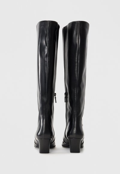 Knee-high black leather boots with a smooth texture, side zippers, and a chunky heel. Minimalist design emphasizes functionality.