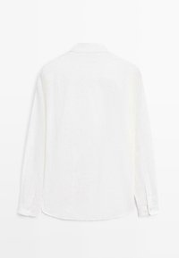 Vue arrière d'une chemise blanche à manches longues avec des rayures verticales subtiles et des poignets boutonnés.