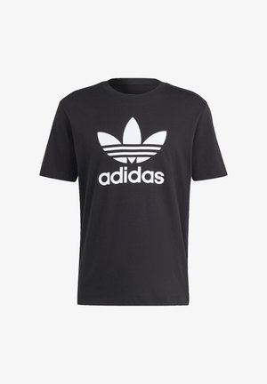Juodas medvilnės marškinėliai su dideliu baltu Adidas logotipu, kuriame yra trys juostelės ir trefoil dizainas krūtinėje. Trumpomis rankovėmis ir apvaliu iškirpimu.