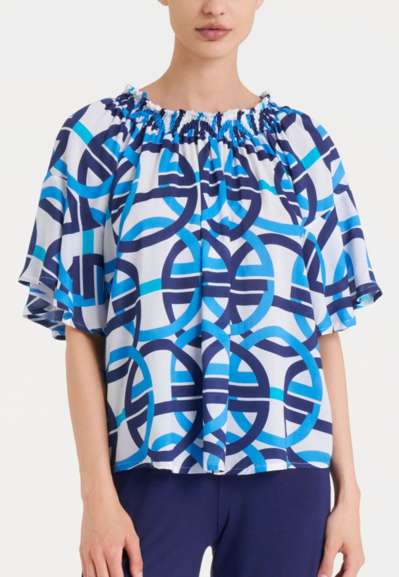 Blusa a maniche corte in tessuto leggero, con un motivo circolare blu e blu scuro, scollatura arricciata e vestibilità morbida.