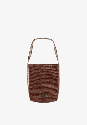 Bolso tipo cubo tejido marrón con una sola correa ancha para el hombro y un pequeño parche negro con el logo en la parte delantera.