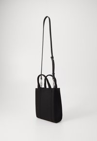 Zwarte stoffen tote bag met twee bovenhandgrepen en een afneembare verstelbare schouderband. Heeft zilverkleurige accenten en een gestructureerde rechthoekige vorm.
