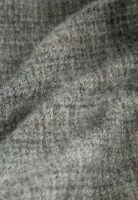 Textured gray fabric with a soft, fuzzy appearance. Subtle pattern with darker flecks, showing a woven, lightweight design.