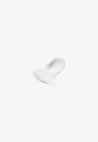 Deux traces superposées de crème ou de lotion blanche sur un fond blanc uni.
