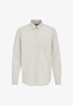 Šviesiai smėlinės spalvos ilgomis rankovėmis marškiniai su apykakle, vienu krūtinės kišenyje ir lygiu medvilnės tekstūros paviršiumi, su mygtukų detalėmis priekyje.