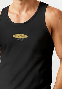 Black tank top with a round neckline, featuring a gold logo that reads "Surf Club NVRLS." The fabric appears smooth and lightweight.