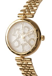 Reloj de oro con una esfera redonda, letras acentuadas en plata, un dial blanco texturizado y una pulsera de eslabones de metal dorado. Los detalles incluyen pequeños cristales.