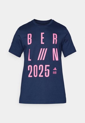 Dunkelblaue Baumwoll-T-Shirts mit auffälligem pinken Text "BERLIN 2025" in diagonalen Linien und einem kleinen Logo in der unteren rechten Ecke.