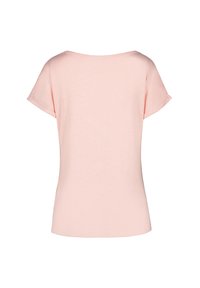 Ljusrosa t-shirt med kort ärm, vid rundad halsringning, mjukt material och rak fåll. Inga mönster eller extra detaljer synliga.