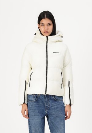 Witte gewatteerde pufferjack met een capuchon, voorzien van zwarte ritsen, zijzakken en een logo op de borst; gladde textuur.