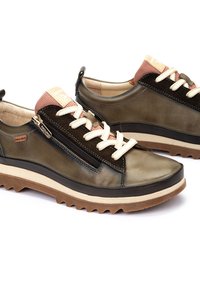 Chaussures en cuir vert avec une finition texturée, dotées d'un accent tissé rose, de lacets crème et d'une fermeture éclair sur le côté. Semelle en caoutchouc avec un motif nervuré.