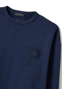 Sudadera azul marino con cuello redondo, que presenta un logo "P" texturizado en azul oscuro en el lado izquierdo del pecho. Tejido suave y puños acanalados.