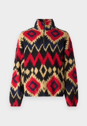 Sudadera de forro polar con cuello alto y media cremallera, con un patrón geométrico multicolor en rojo, negro, dorado y azul. Textura suave.