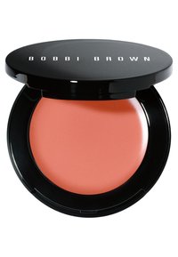 Blush cremoso in una confezione nera. Il prodotto è di una tonalità corallo pesca con una texture liscia. La confezione ha una finitura lucida e un logo sulla parte superiore.