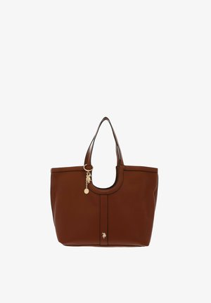 Sac cabas en cuir marron avec doubles anses, breloque dorée avec logo près de la poignée et petit emblème avec logo au centre avant.