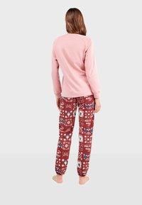 Ensemble de vêtements d'intérieur pour adulte comprenant un haut à manches longues rose et un pantalon bordeaux à motifs avec des designs floraux et graphiques. Tissu doux, coupe d�écontractée.