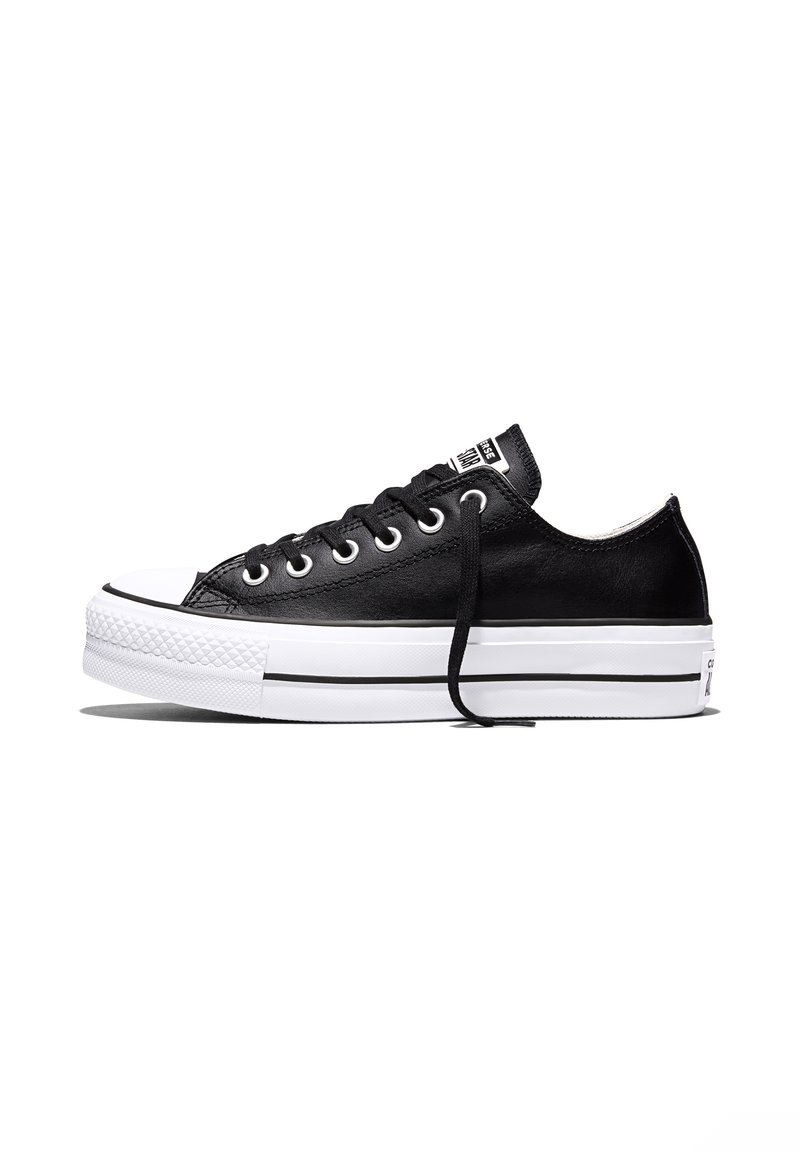 Schwarzer Low-Top-Sneaker mit weißer Gummisohle, weißer Zehenkappe, schwarzen Schnürsenkeln und Metallösen, seitlich auf weißem Hintergrund dargestellt.