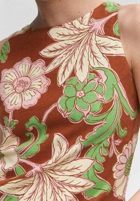 Robe marron sans manches avec de grands motifs floraux verts et roses. Dessins de feuilles et de fleurs avec des détails complexes sur toute la surface.