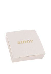 Różowy kwadratowy pudełko o gładkiej fakturze, z napisem "amor" w złotej literze na wieczku. Subtelny podniesiony detal krawędzi.