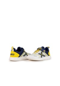 Zapatillas deportivas con parte superior de malla blanca, acentos en color marino, detalles en amarillo y marca en negro. Suela texturizada con construcción flexible para mayor comodidad.