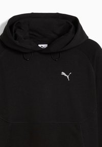 Svart huvtröja i mjukt tyg, med en framficka i kängurustil, snörning och en reflekterande silver Puma-logotyp på bröstet.