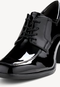 Scarpa da cerimonia in pelle verniciata nera con superficie liscia, design con lacci e tacco elegante. Presenta cuciture discrete e una punta arrotondata.