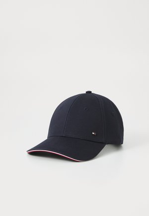 Marineblå baseballcap med buet skygge, der har et lille logo-patch og en rød og hvid kant langs skyggen. Materiale af bomuld.