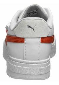 Valged nahast tenniseketsid, millel on struktureeritud kummist tald, oranž riba ja hõbedane Puma logo kanna peal.
