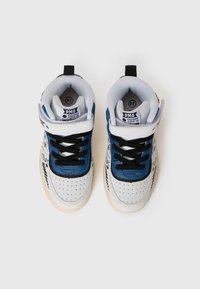 Witte en blauwe sneakers met geperforeerde neus, zwarte veters, gevoerd kraag en kleurrijke grafische details op de zijkant. Tan rubberen buitenzool.