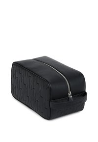 Svart rektangulær toalettveske med teksturert mønster, med en glatt lærøvre, sølvglidelås og et sidehåndtak.