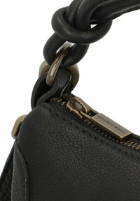 Borsa a mano in pelle nera con finitura texture, chiusura con zip e zip in tono bronzo, e un particolare manico annodato unico.